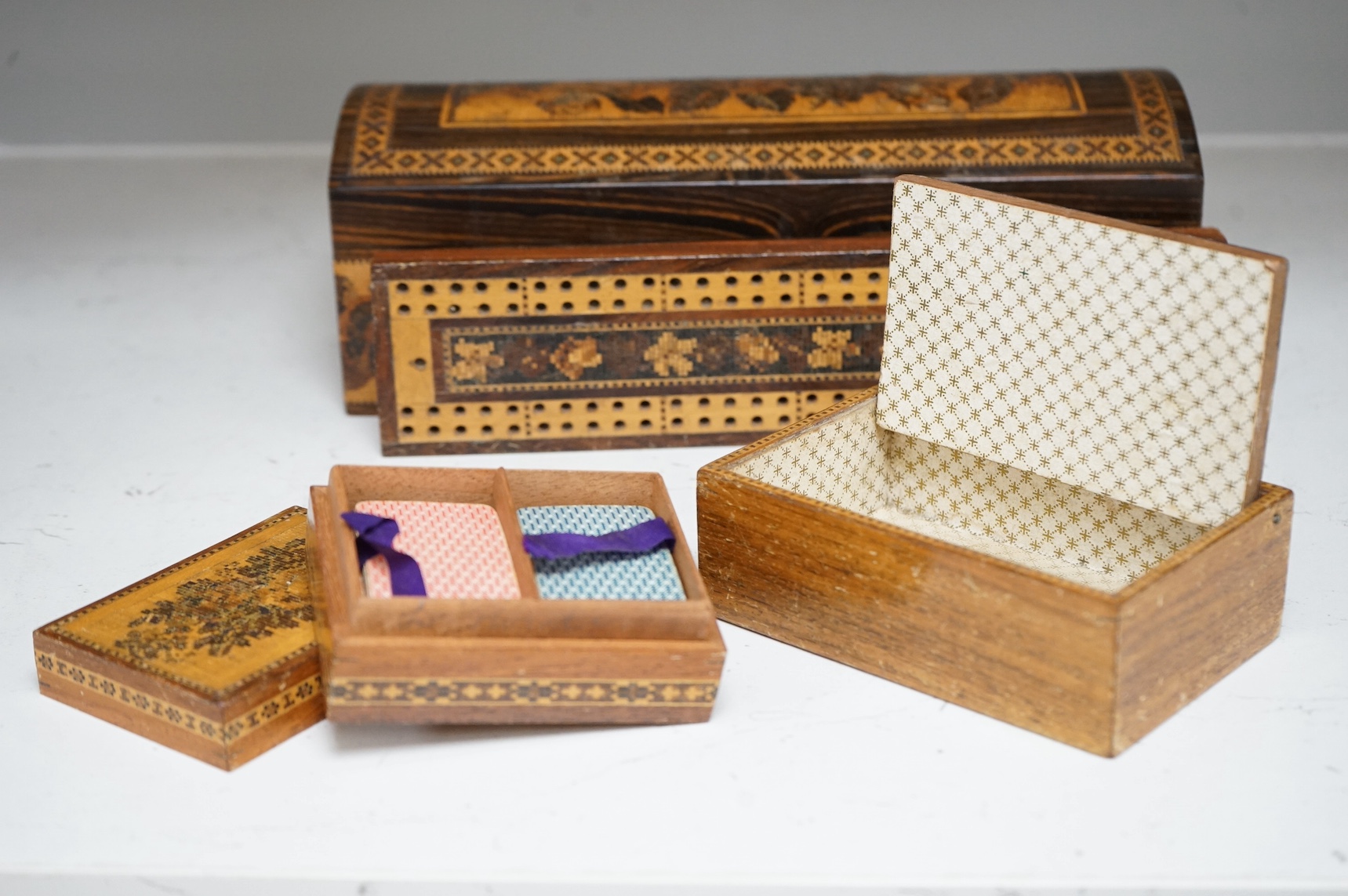 Three Tunbridge Ware boxes to include a glove box, another housing a set of miniature playing cards and a cribbage board, 24cm. Condition - fair